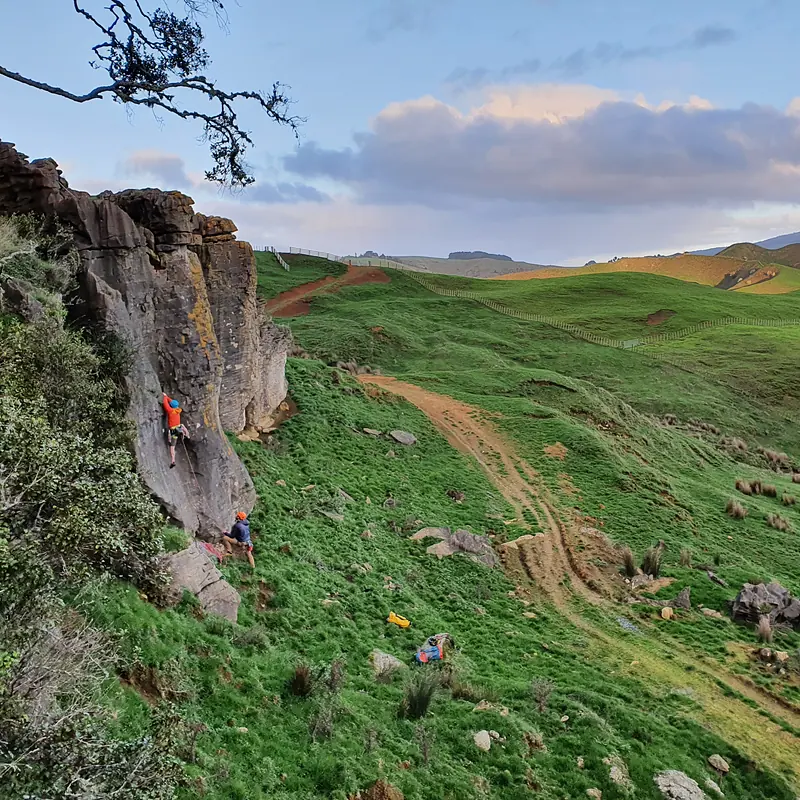 Sport climbing at a crag above rolling green farmland near Raglan